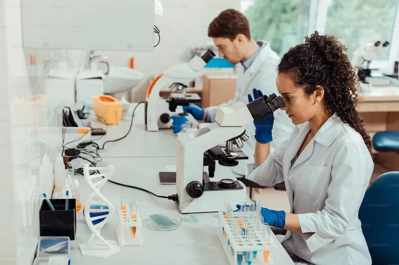 Scientists conducting laboratory research using microscopes and test tubes