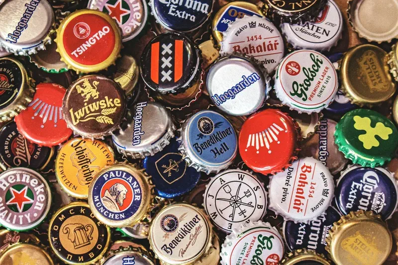 Collection of colorful beer bottle caps featuring various brand logos and designs