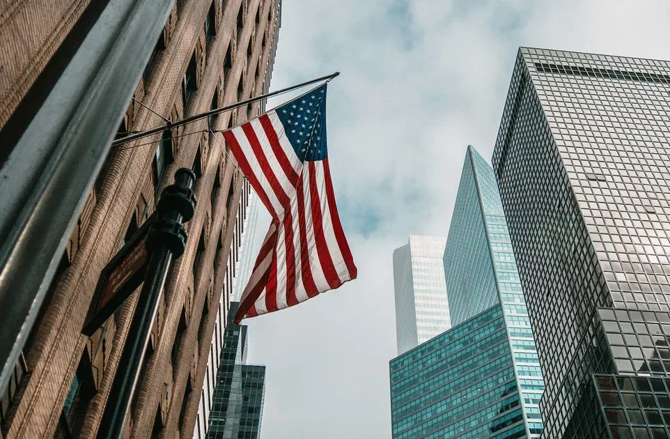 United States flag displayed among modern skyscrapers in a financial district