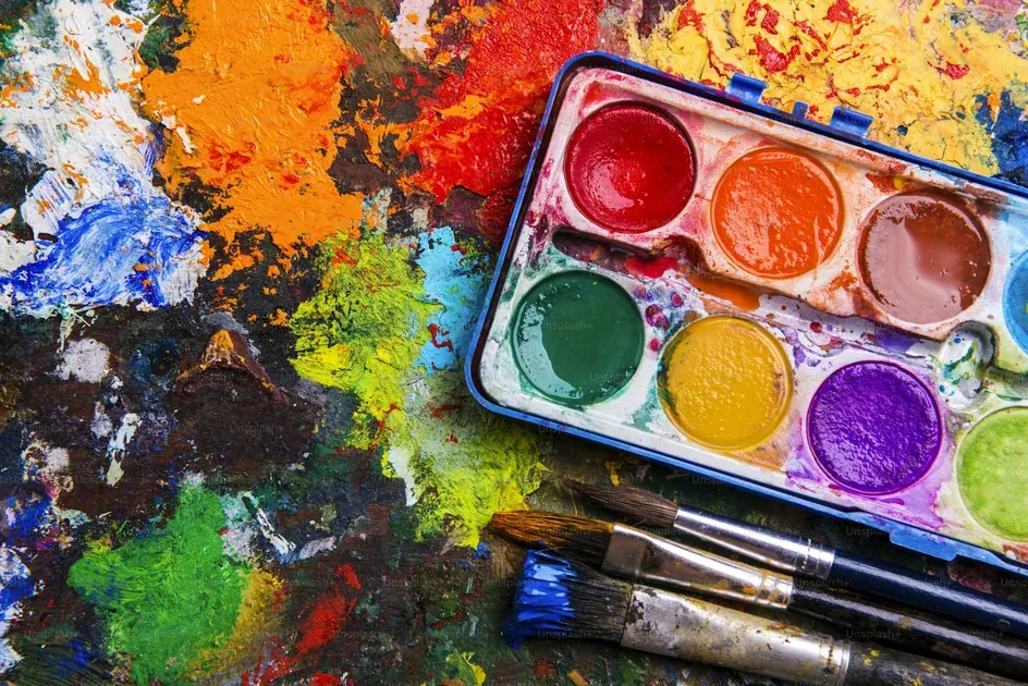 Colorful paint palette with brushes on an artist workspace showing creative process