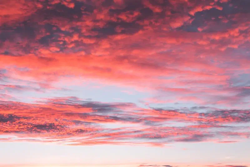 Vibrant pink and orange clouds across a dramatic sunset sky